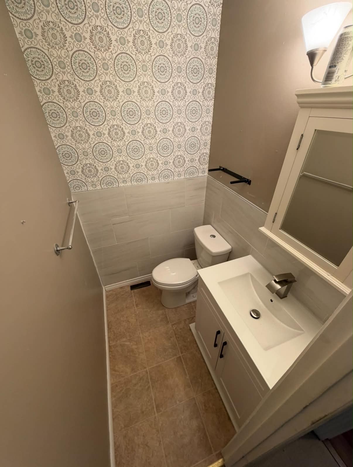 Completed bathroom with toilet, vanity, and tiled walls
